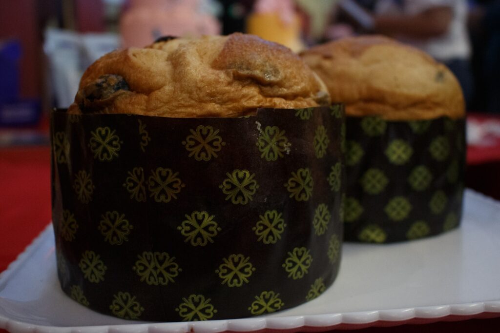 Two panettone cakes in decorative paper molds.